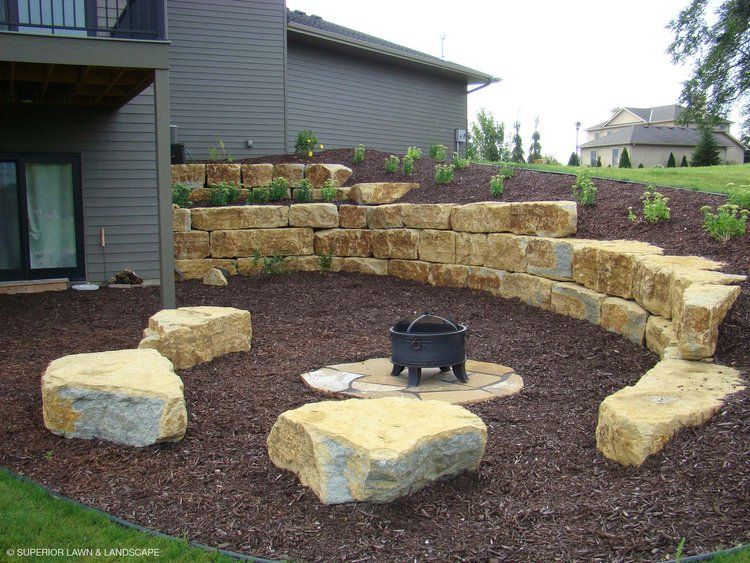 A fire pit surrounded by rocks in front of a house