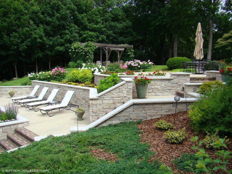 A patio with lawn chairs and a pergola in the background