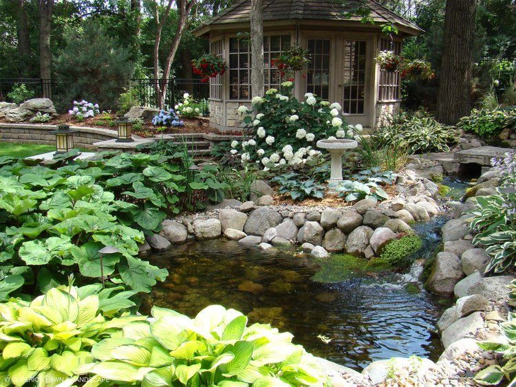 A pond in a garden with a gazebo in the background