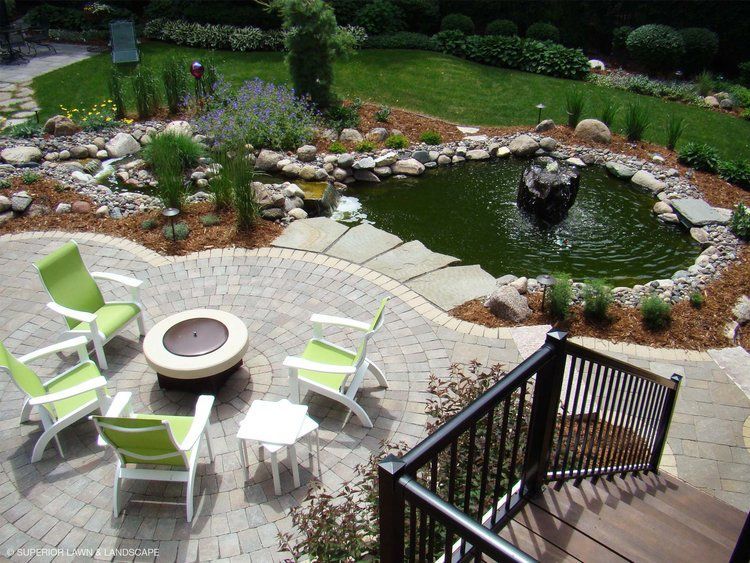 An aerial view of a patio with a fire pit and chairs