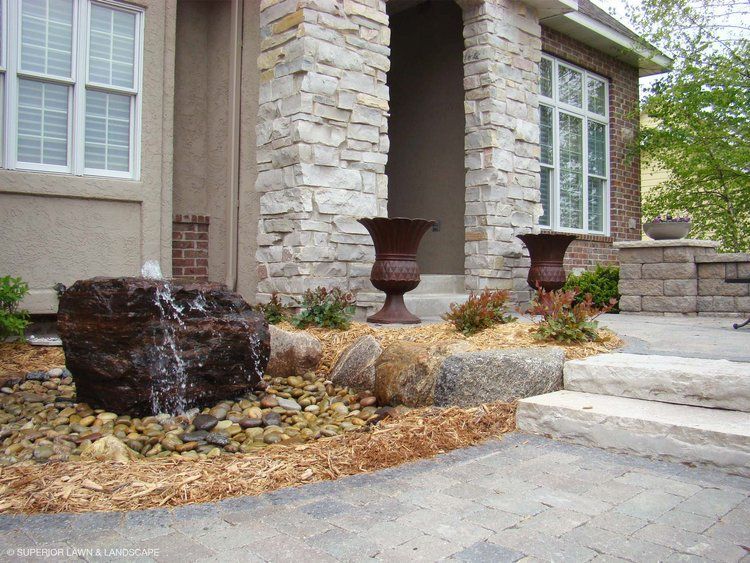 A stone house with a fountain in front of it