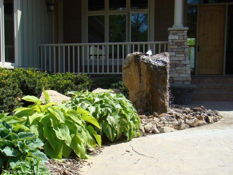 A house with a porch and a fountain in front of it