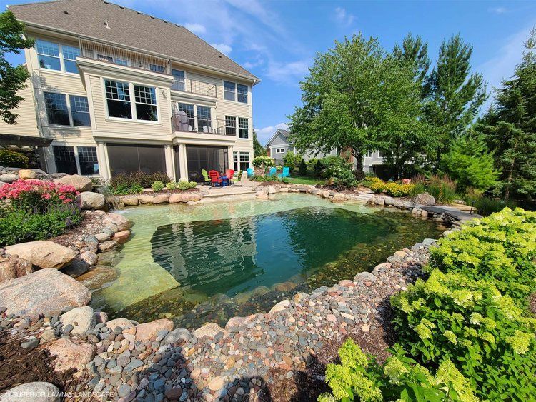 A large house with a large pond in front of it.