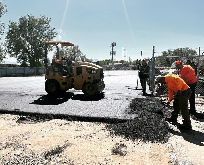 a group of construction workers are working on a road
