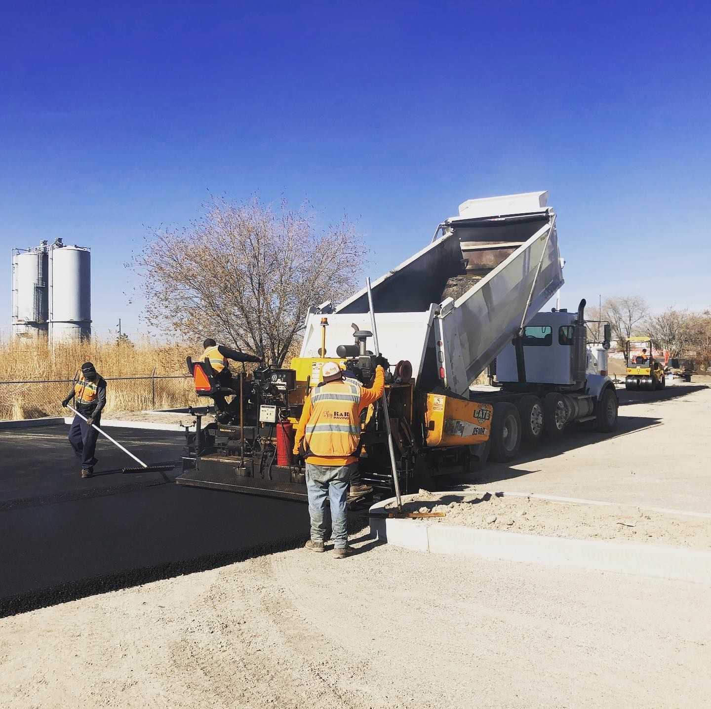 a dump truck is being loaded with asphalt on a construction site
