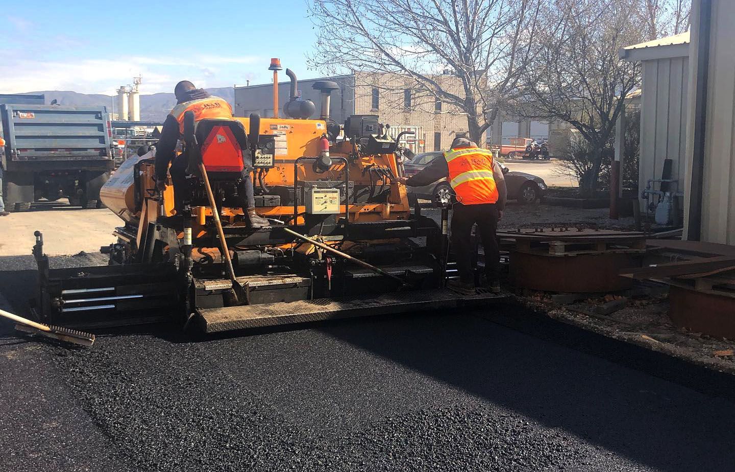 a group of construction workers are working on a road
