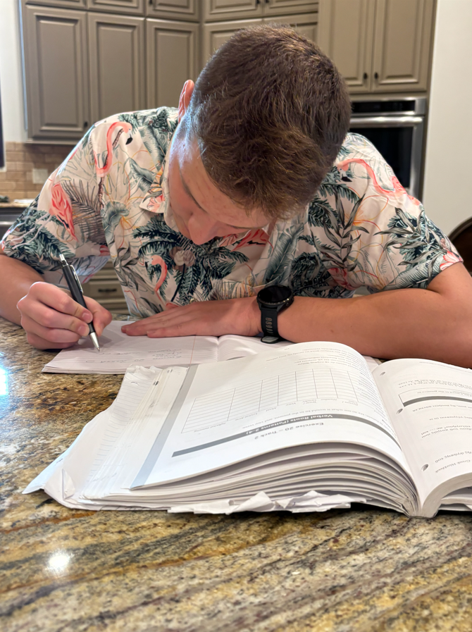 a student taking notes from a book