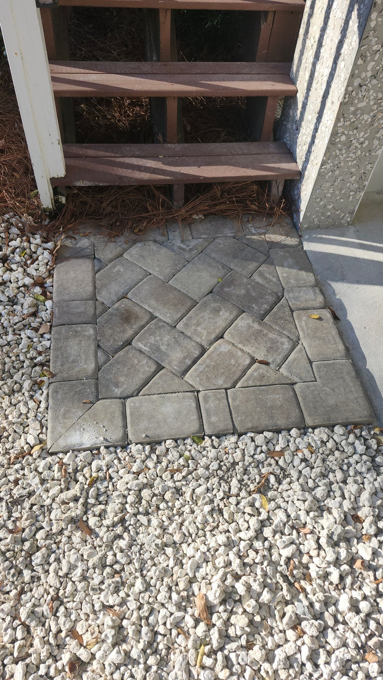 A lush green lawn in front of a house with a walkway.