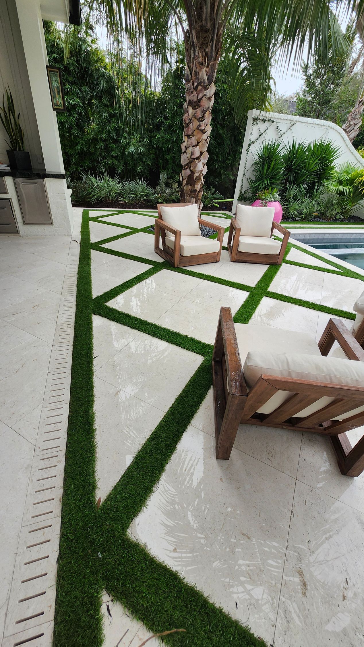 A patio with chairs and a swimming pool in the background.
