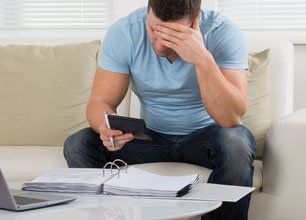 Worried mid adult man calculating home finance at table