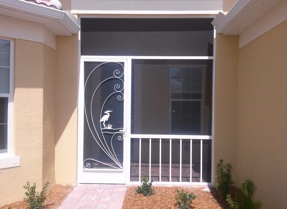 White screen door with ornate bird design, leading to a screened porch. Beige exterior.