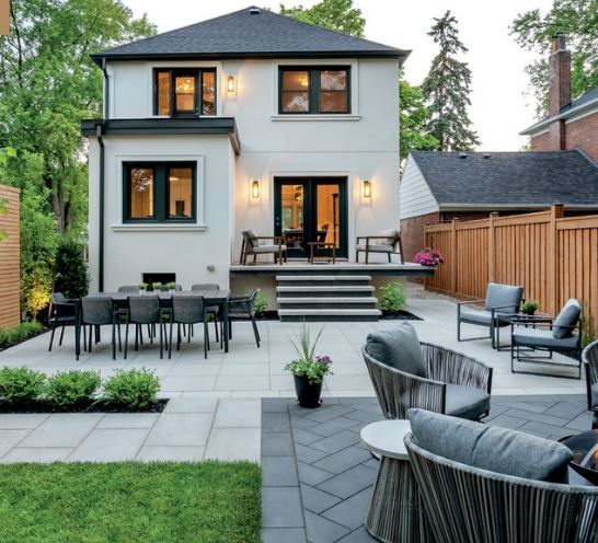 The backyard of a house has a patio with a table and chairs