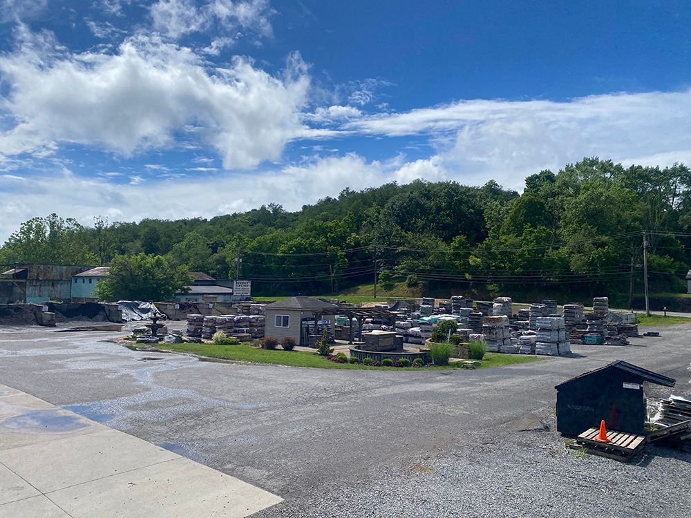 A large graveyard with a lot of graves and trees in the background on a sunny day.