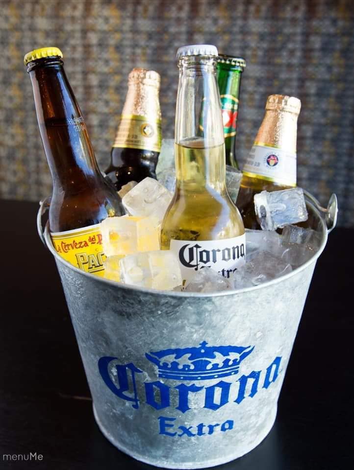 A metal bucket filled with ice and beer bottles.