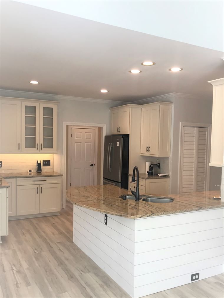 A kitchen with white cabinets and granite counter tops
