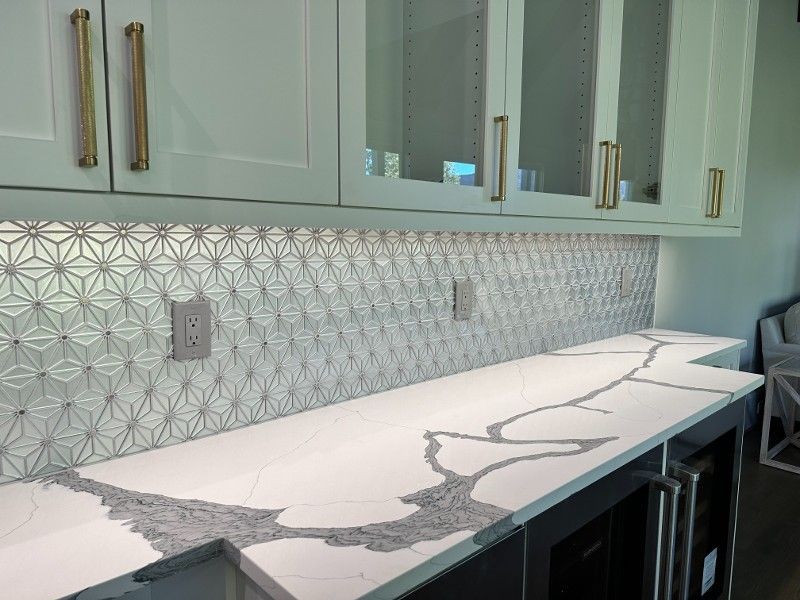 A kitchen with white cabinets and a gray counter top.