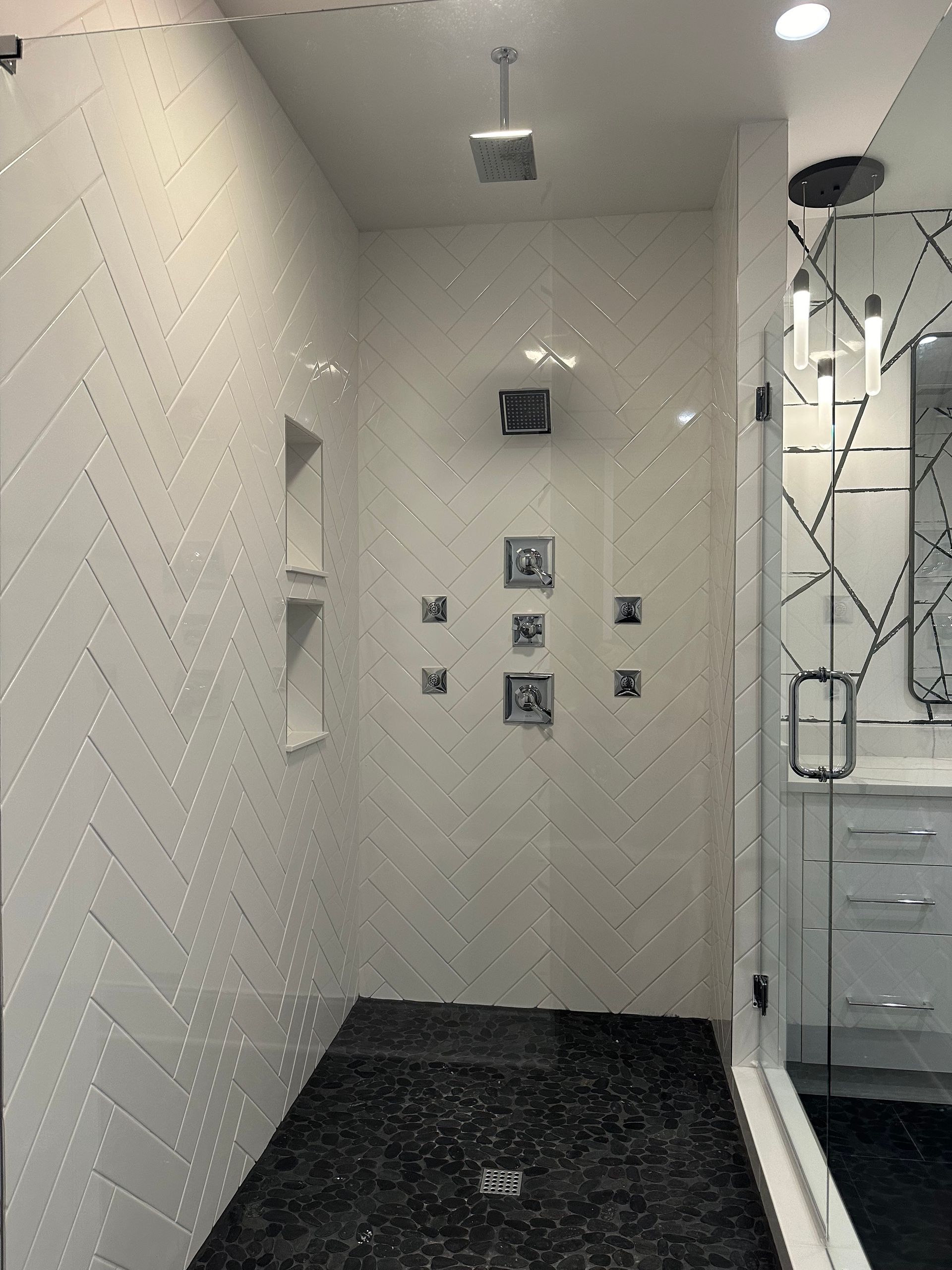 A bathroom with white tiles and a walk in shower