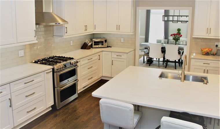 A kitchen with white cabinets and stainless steel appliances