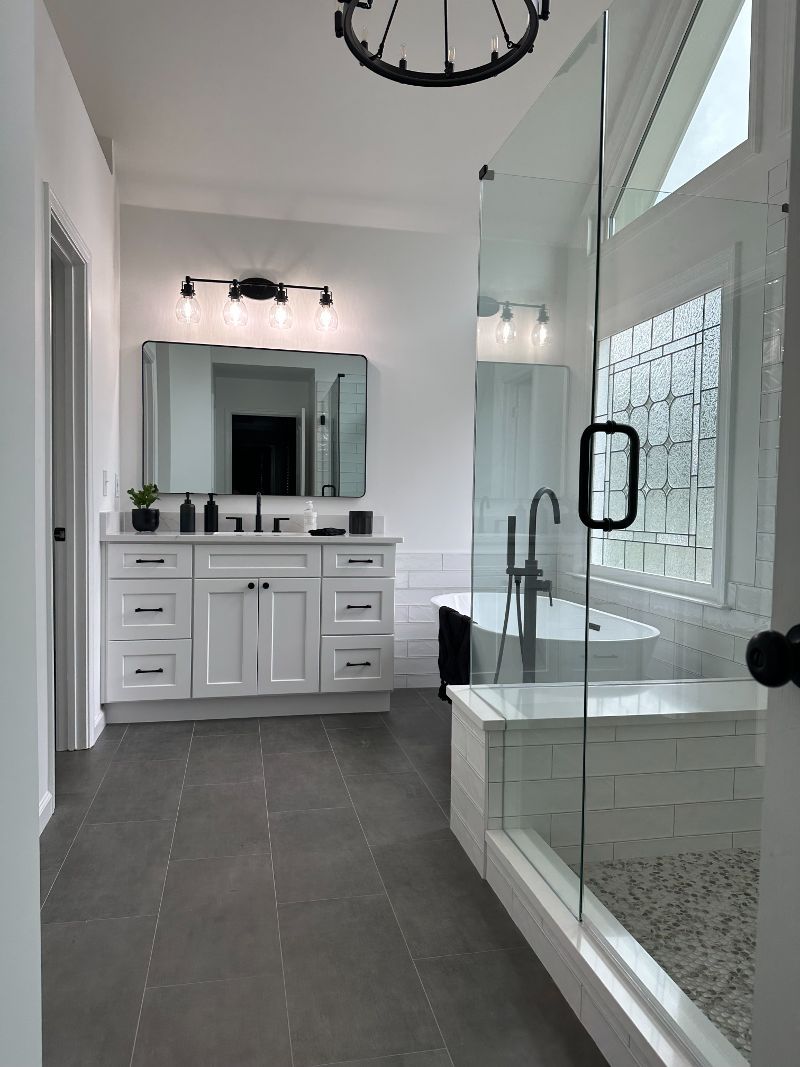 A bathroom with two sinks, a tub, and a walk-in shower.