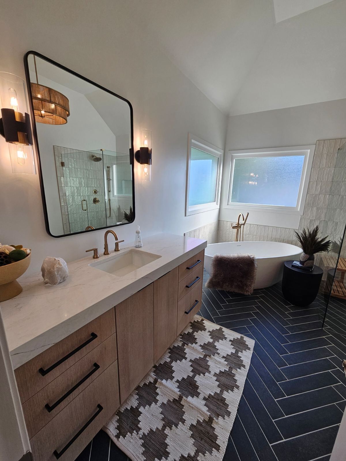 A bathroom with a tub, sink, mirror, and rug.