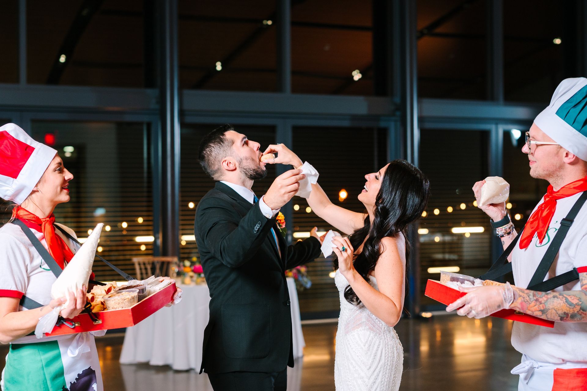 Multi-tiered octagon-shaped wedding cake with floral decorations, on a black table.
