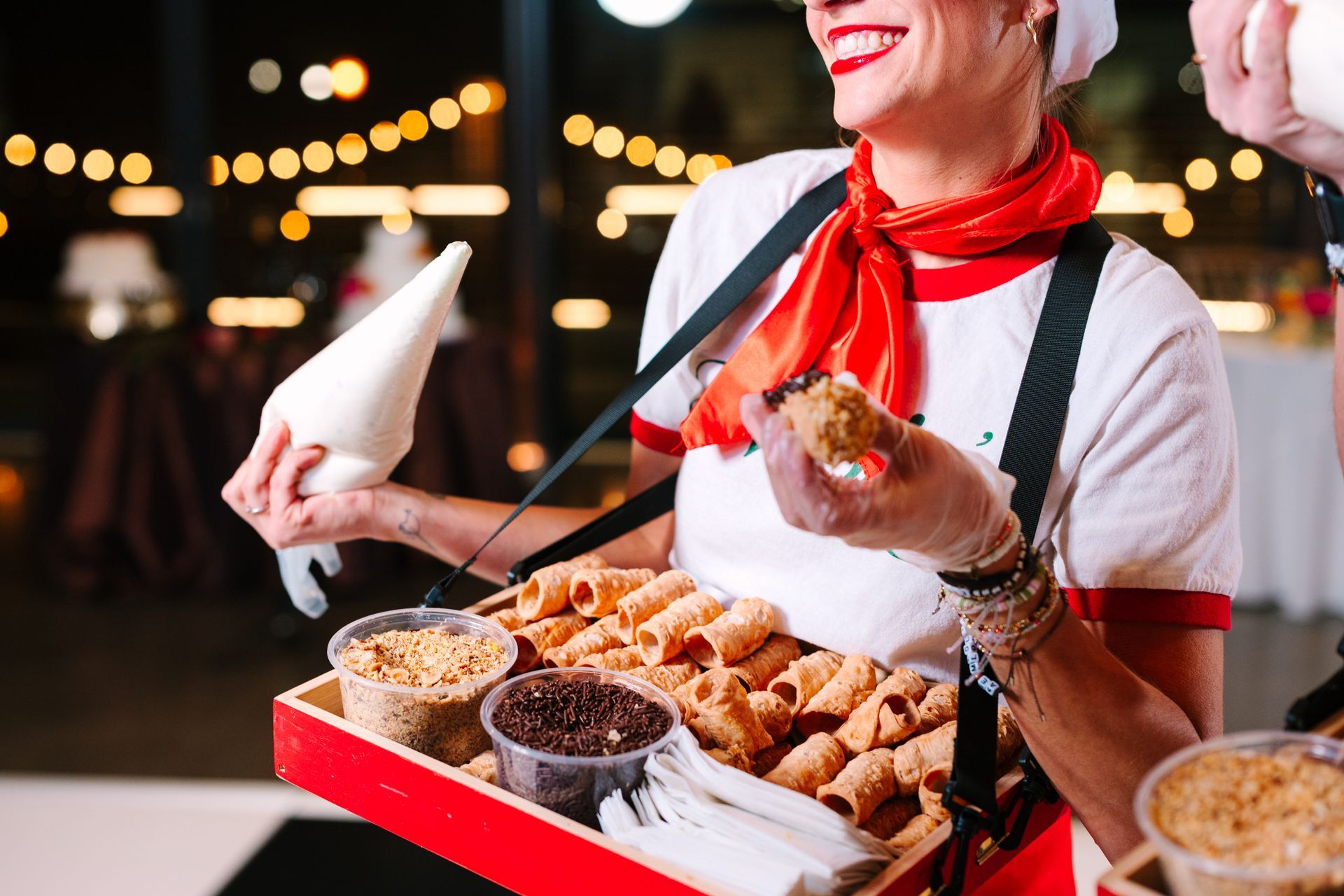 Three-tier white cake decorated with dark purple and green floral accents, topped with flowers.