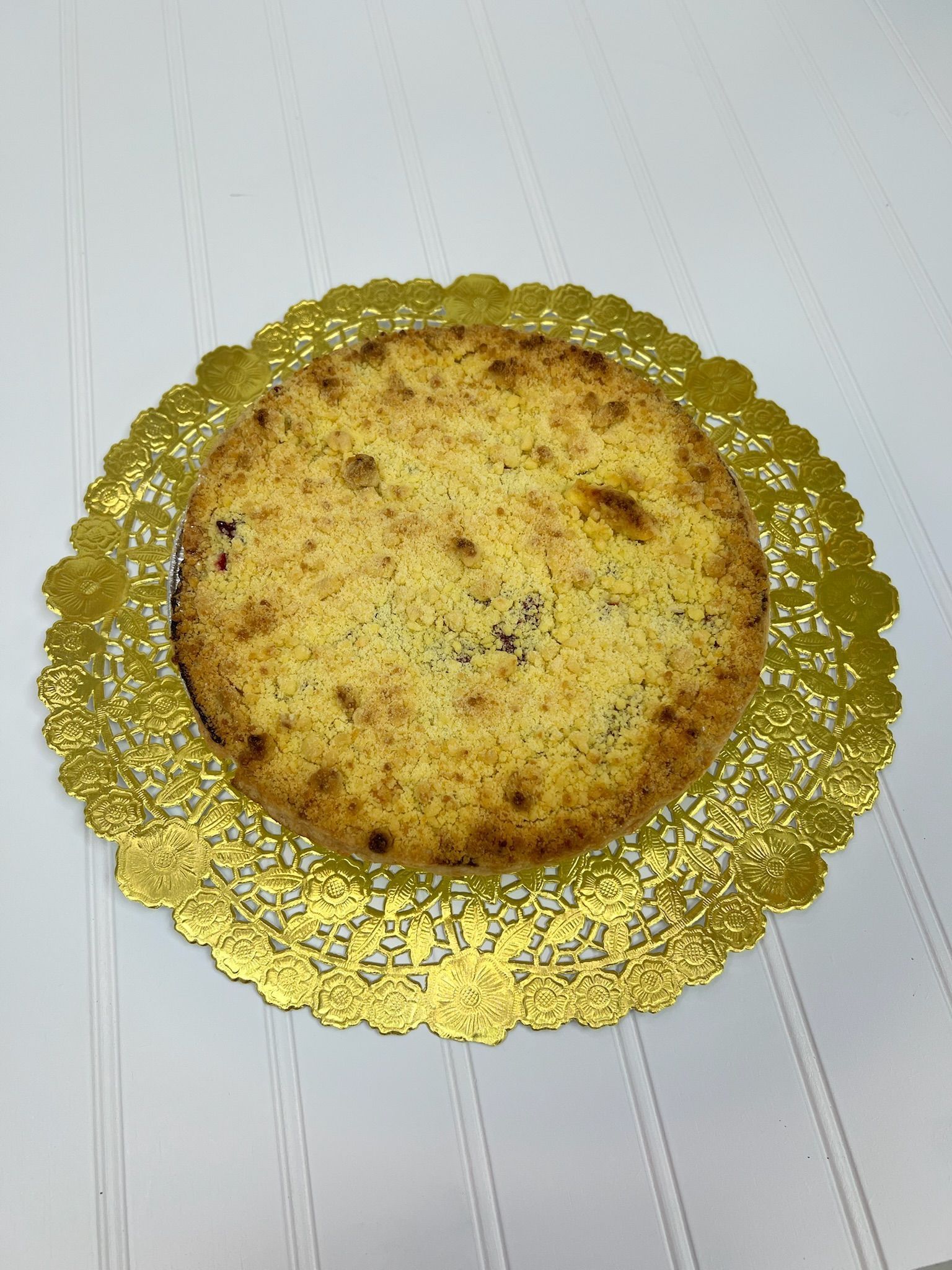 Round cake on a gold doily, set against a white background.