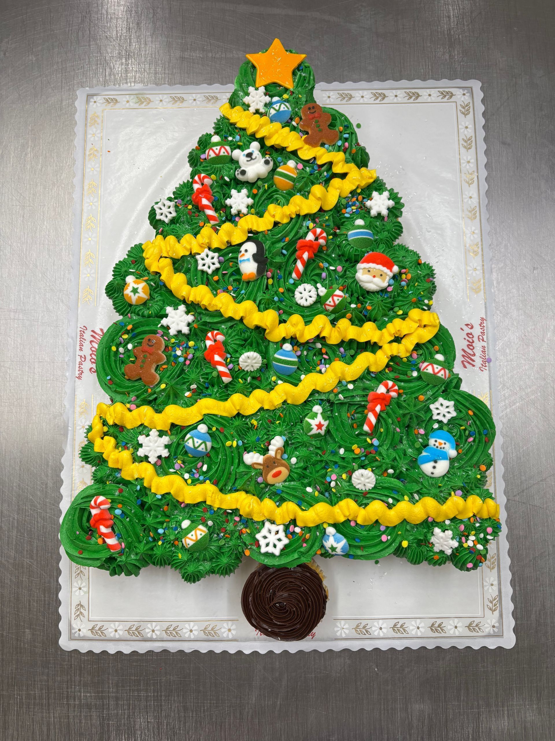 Christmas tree cake decorated with green frosting and candy ornaments.