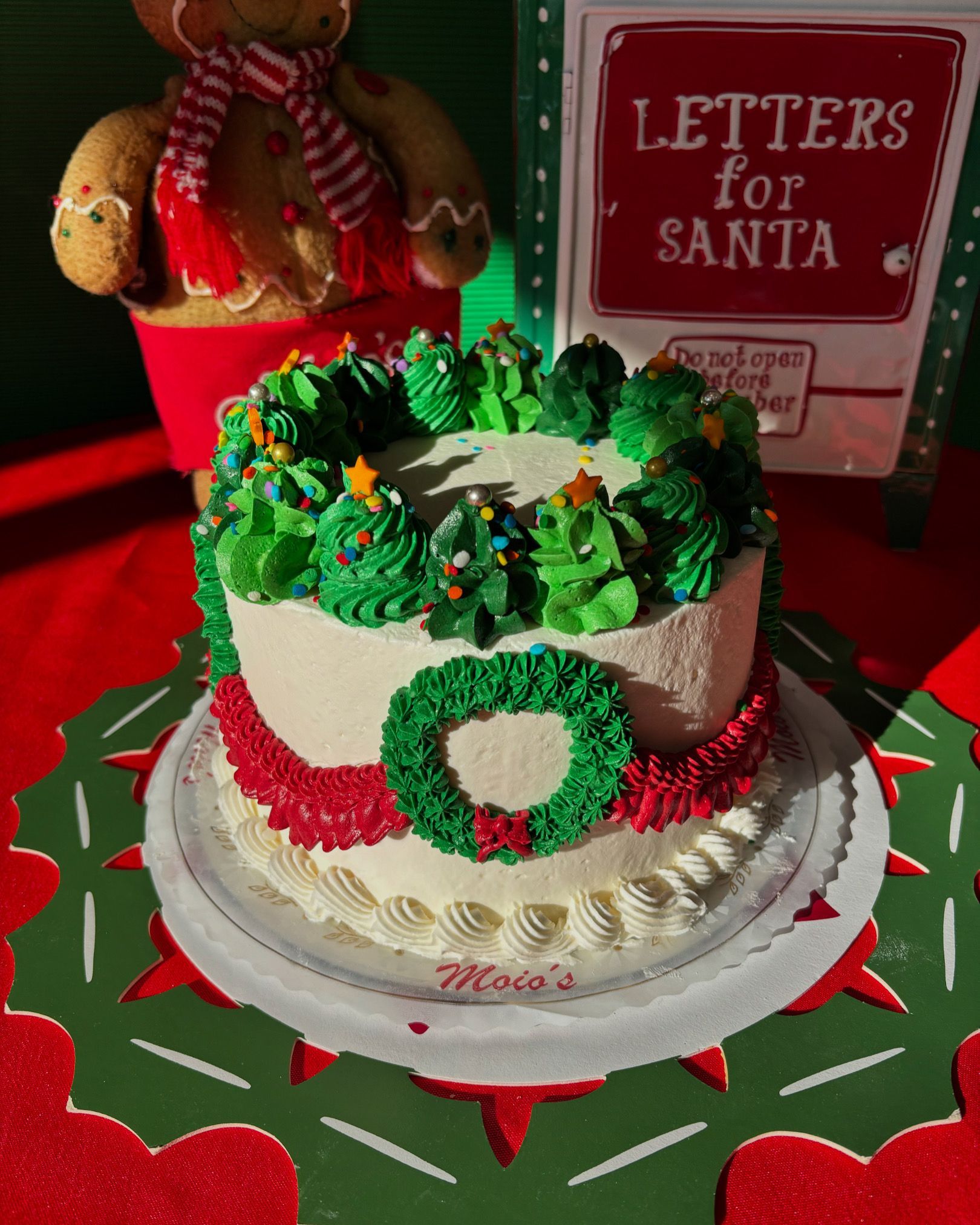 Christmas cake with green frosting and decorations, red and green accents.