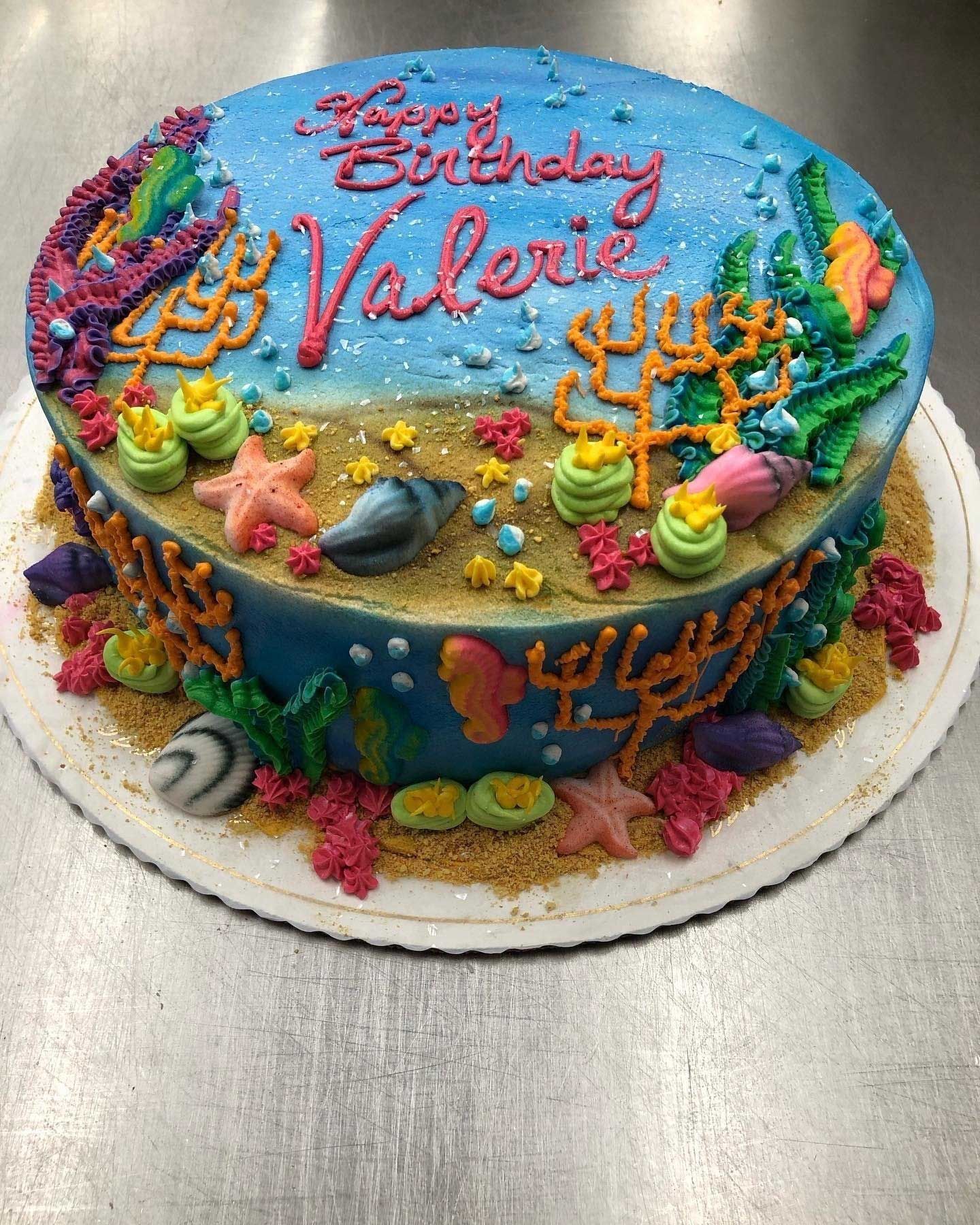 Birthday cake decorated with an underwater scene, Valerie's name on top. Colorful coral, starfish, shells.
