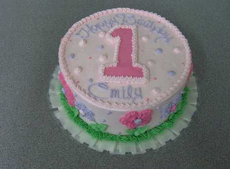 A round birthday cake with pink frosting that says