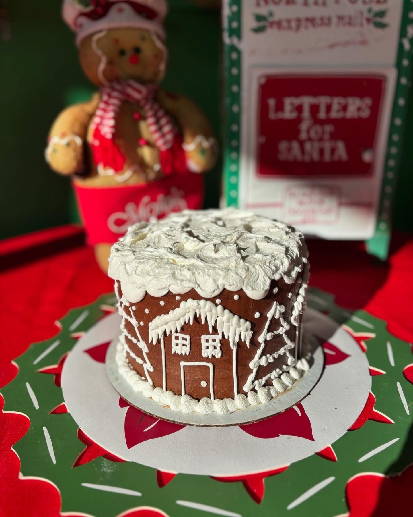 Gingerbread house cake on a Christmas-themed platter