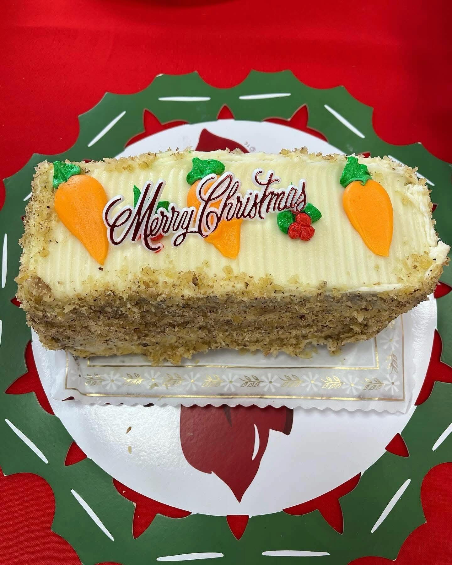 Christmas carrot cake with Merry Christmas icing and carrot decorations.
