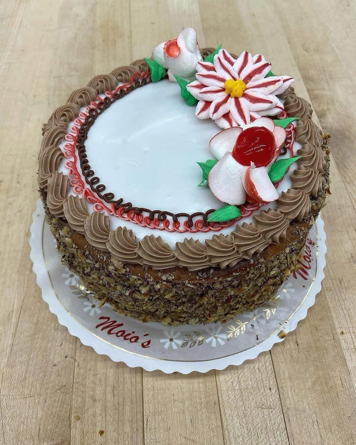 Cake decorated with flowers and chocolate frosting on a paper doily.