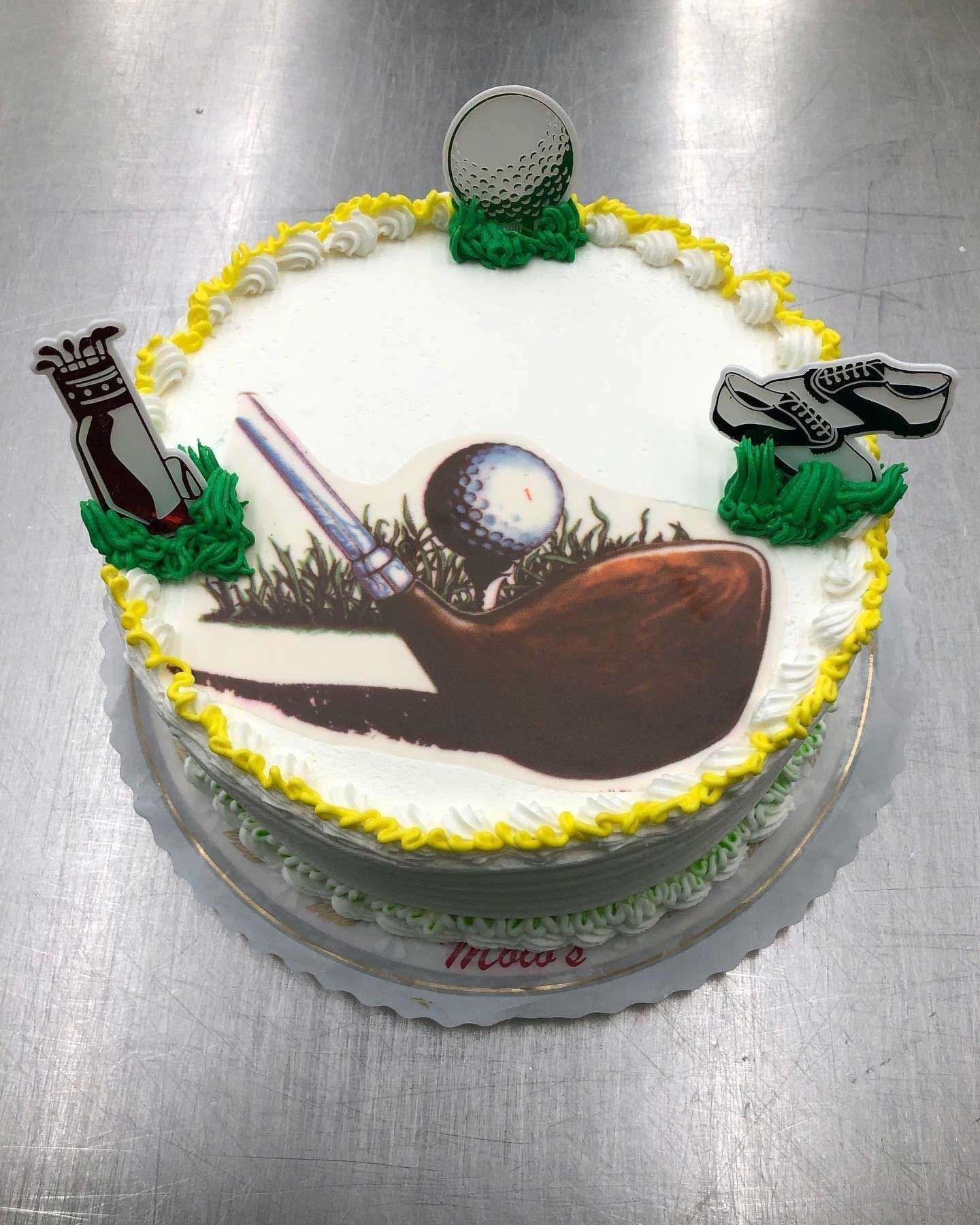 Golf-themed cake with a golf club graphic, golf ball, and golf shoe decorations.