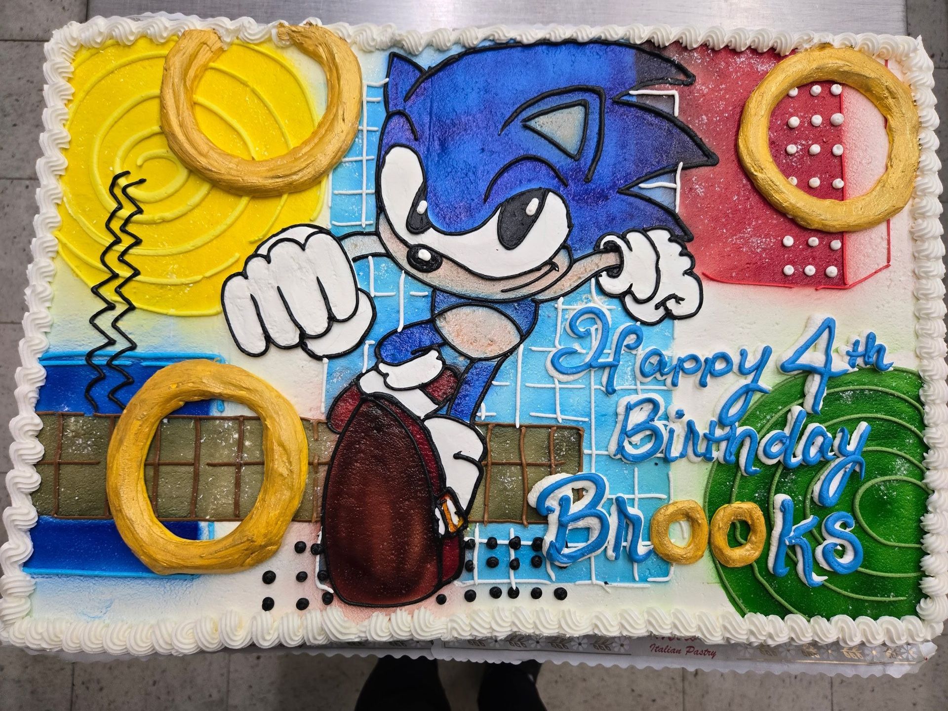 Sonic the Hedgehog cake with rings and Happy 4th Birthday Brooks in blue frosting.