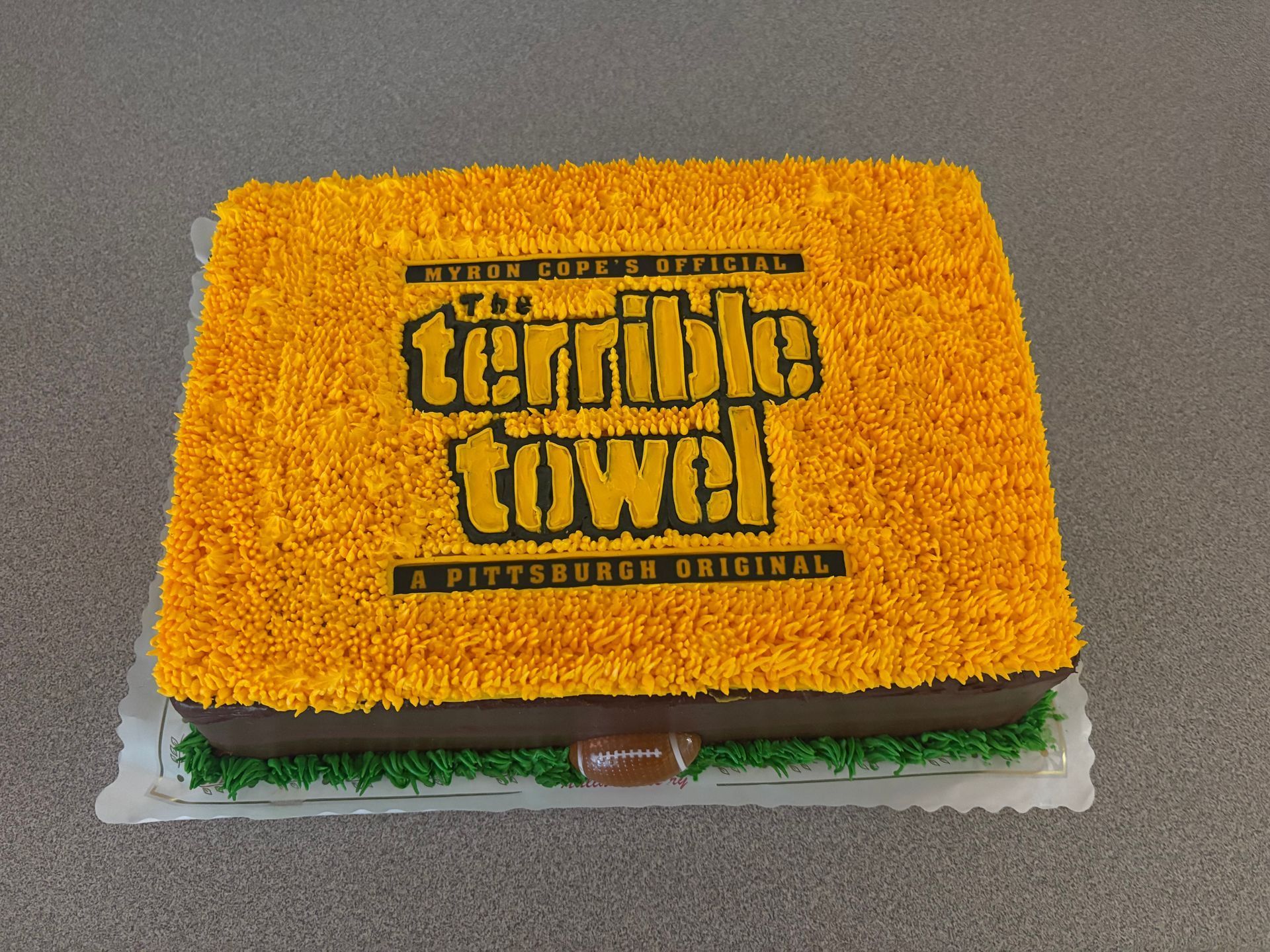 Cake decorated to look like the Pittsburgh Steelers' Terrible Towel, with yellow frosting and logo.