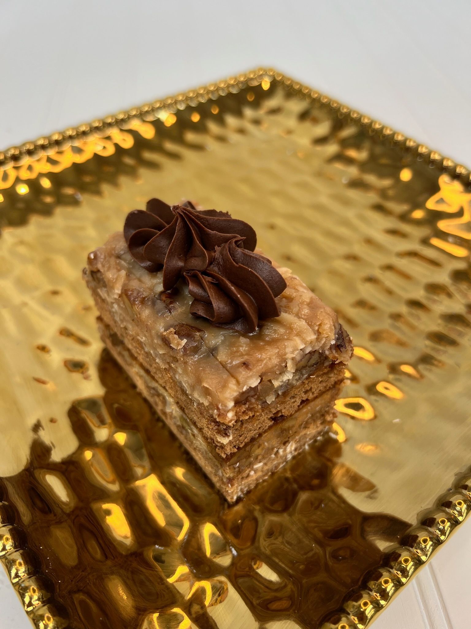 Chocolate pastry on a gold, textured plate.
