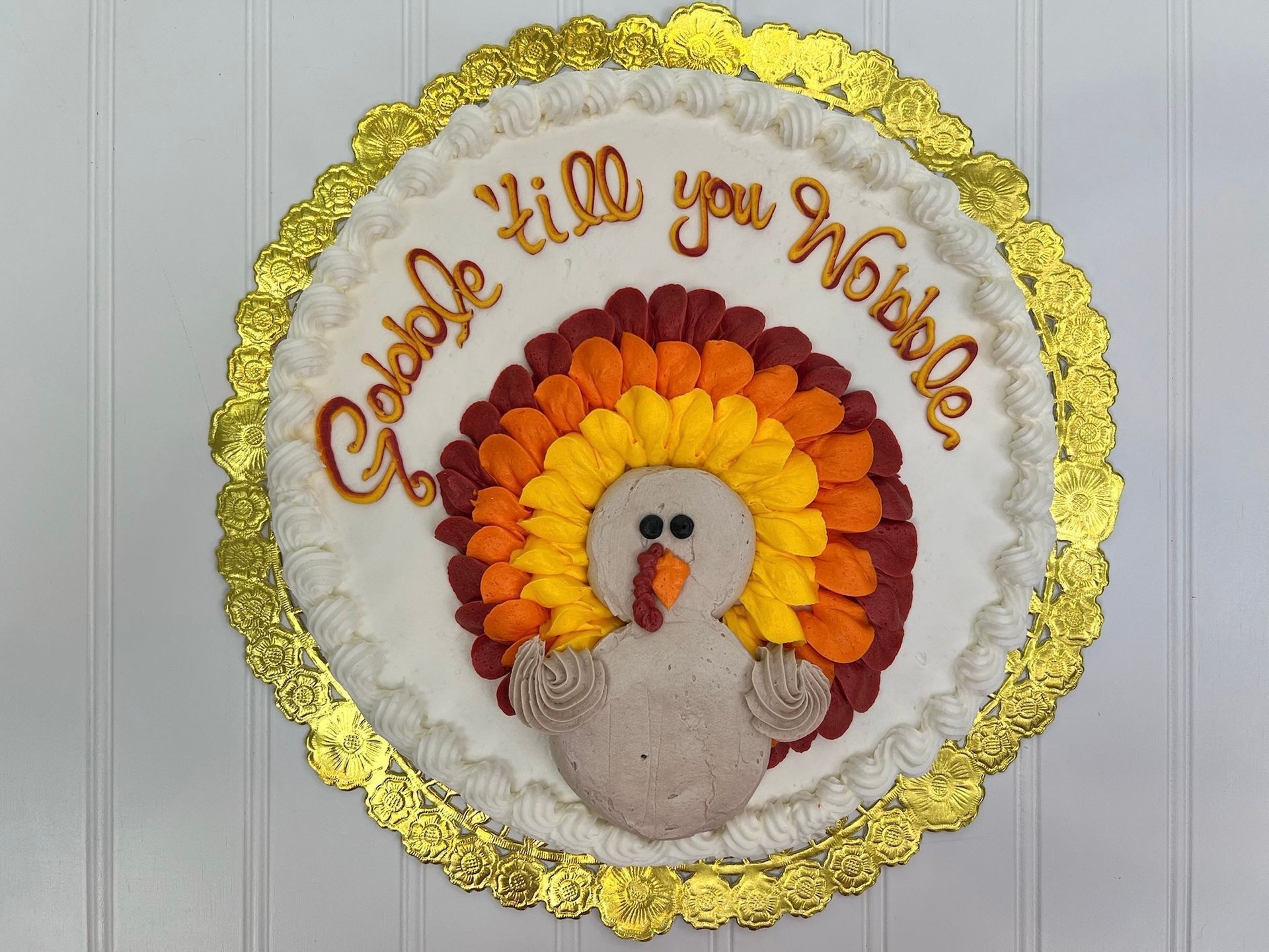 Thanksgiving cake decorated with a turkey and the words Gobble 'til you Wobble.