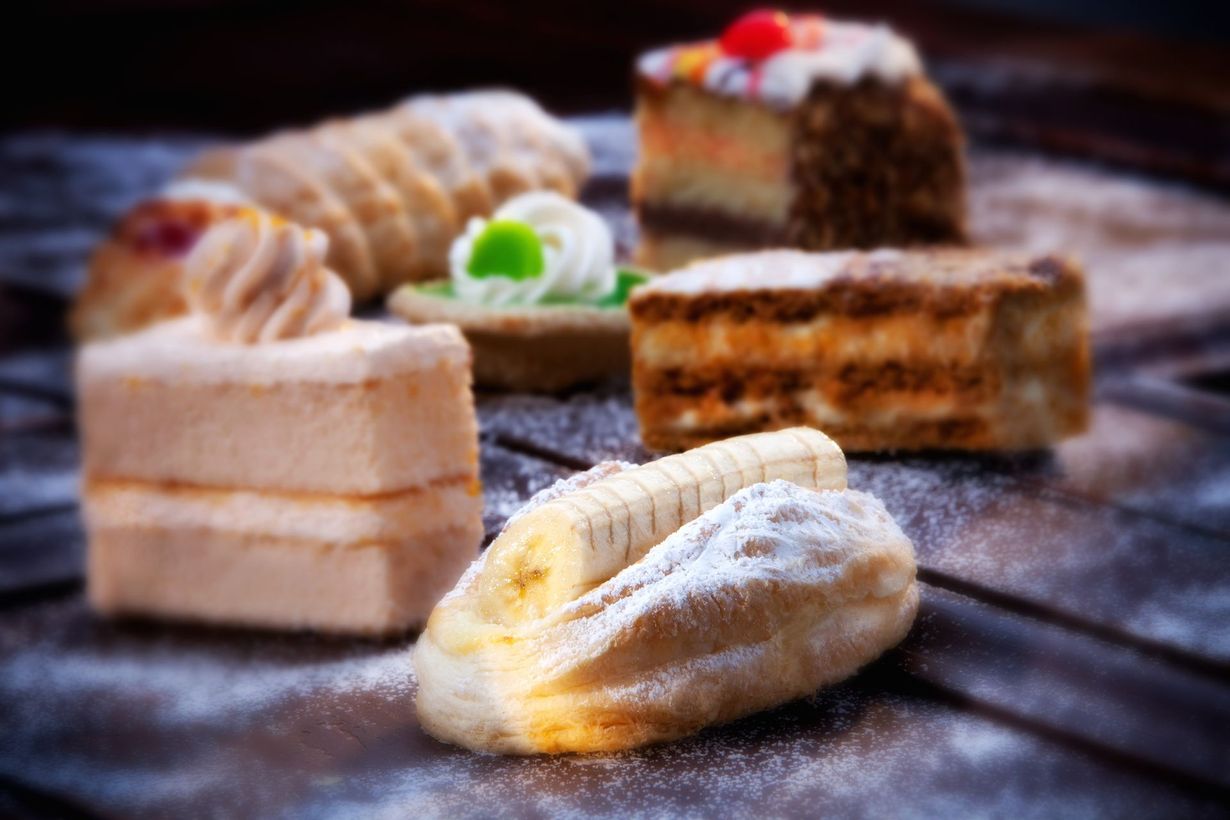 Assorted pastries dusted with powdered sugar on a wooden surface.