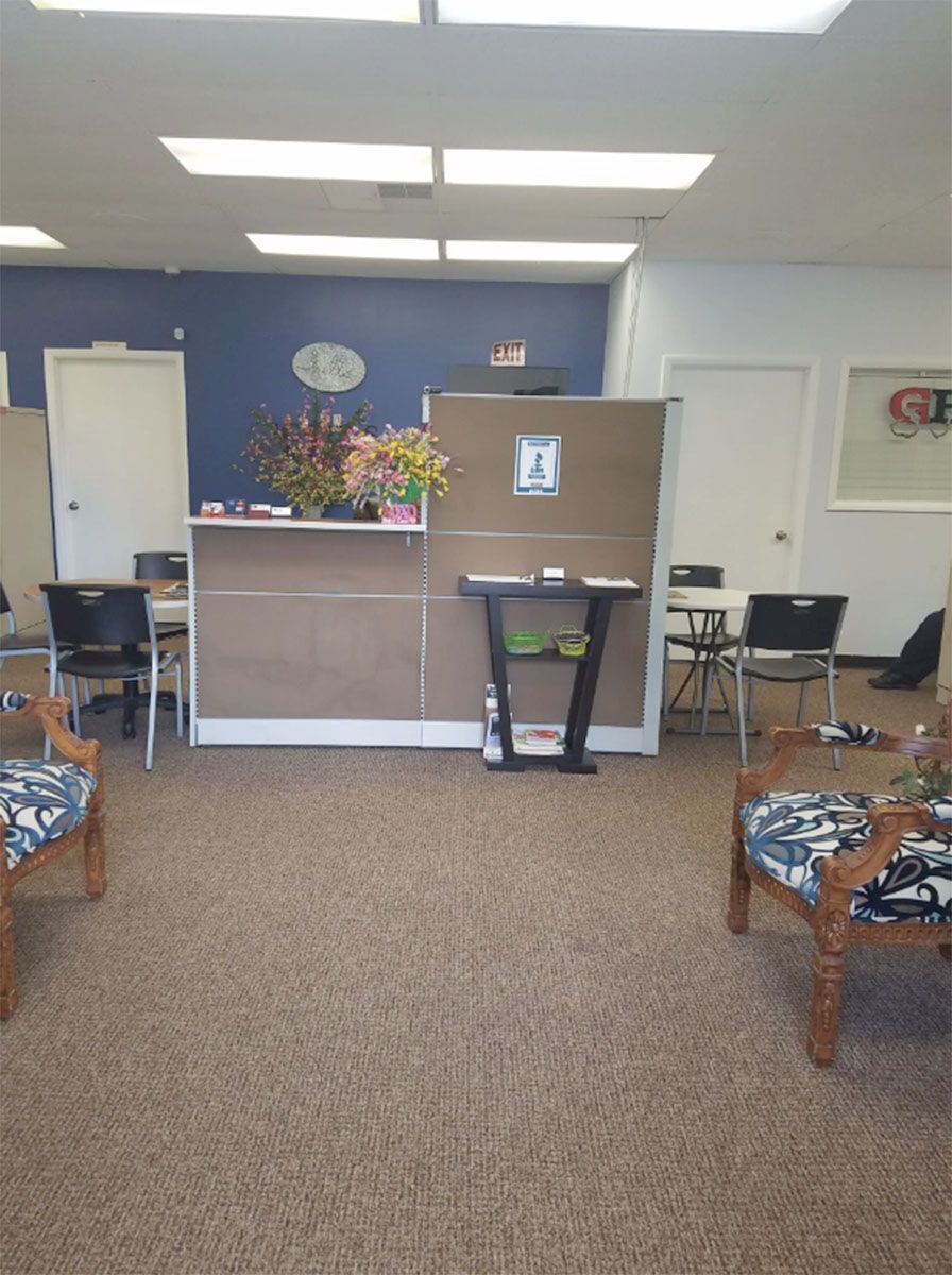 A waiting room with chairs , tables and a counter