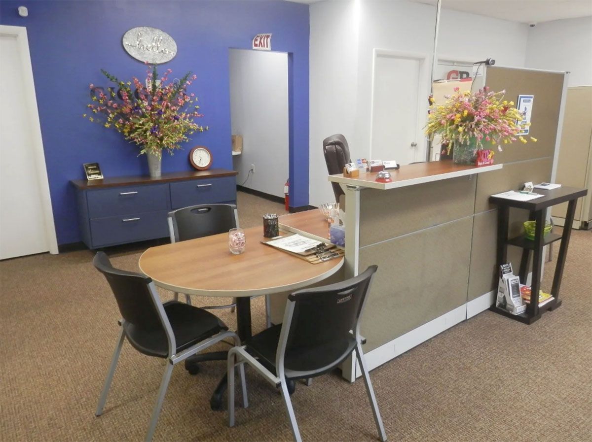 A room with a table and chairs and flowers on the wall
