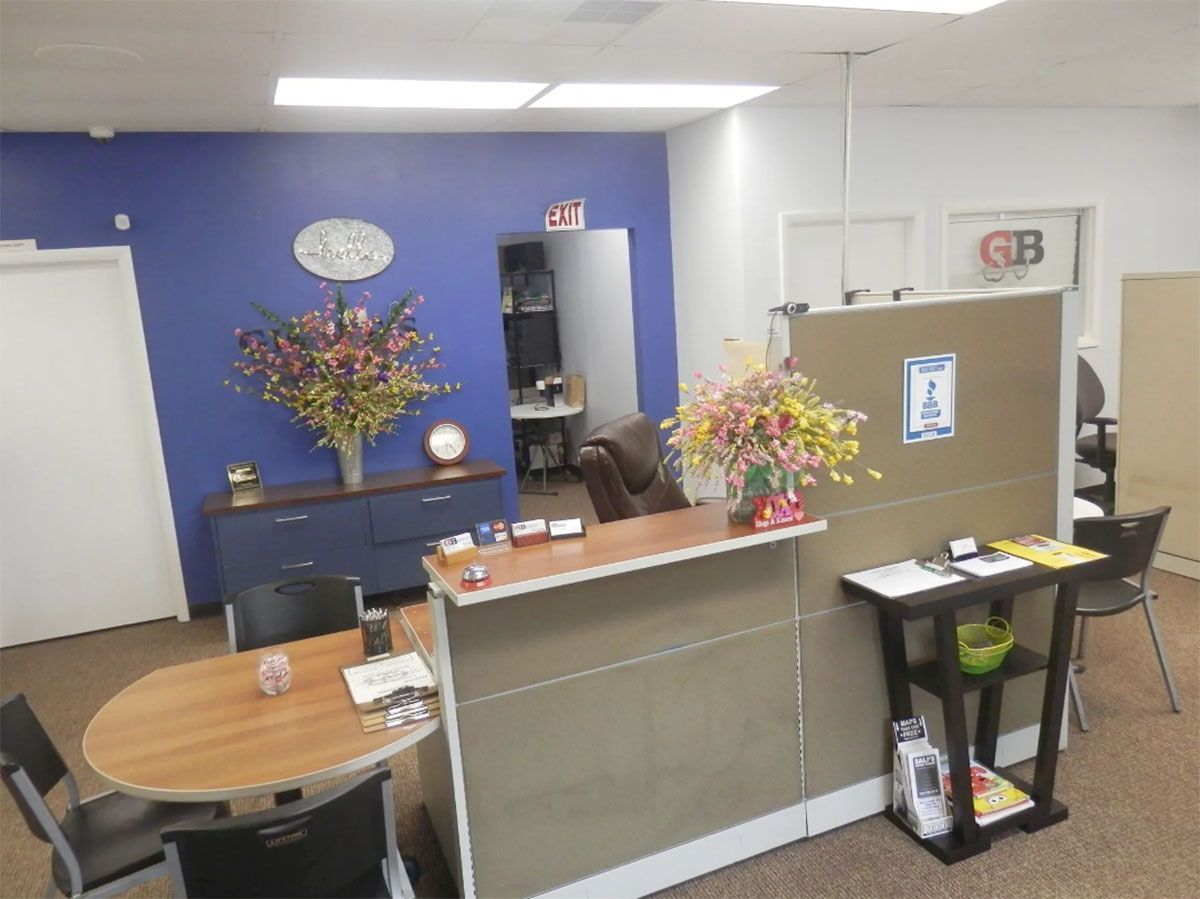 A reception area with a table and chairs and a clock on the wall