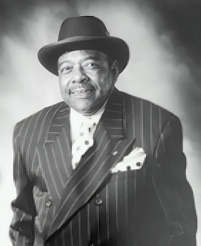 A black and white photo of a man in a suit and hat