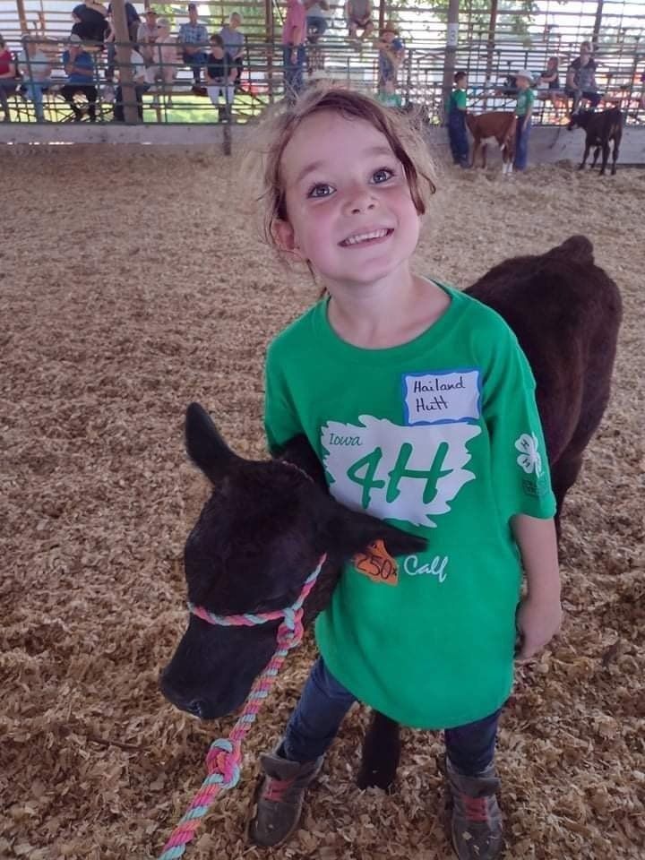 A little girl wearing a green shirt with the number 44 on it