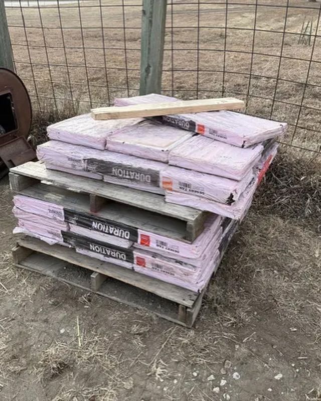 A stack of pallets filled with purple foam sitting on top of each other.