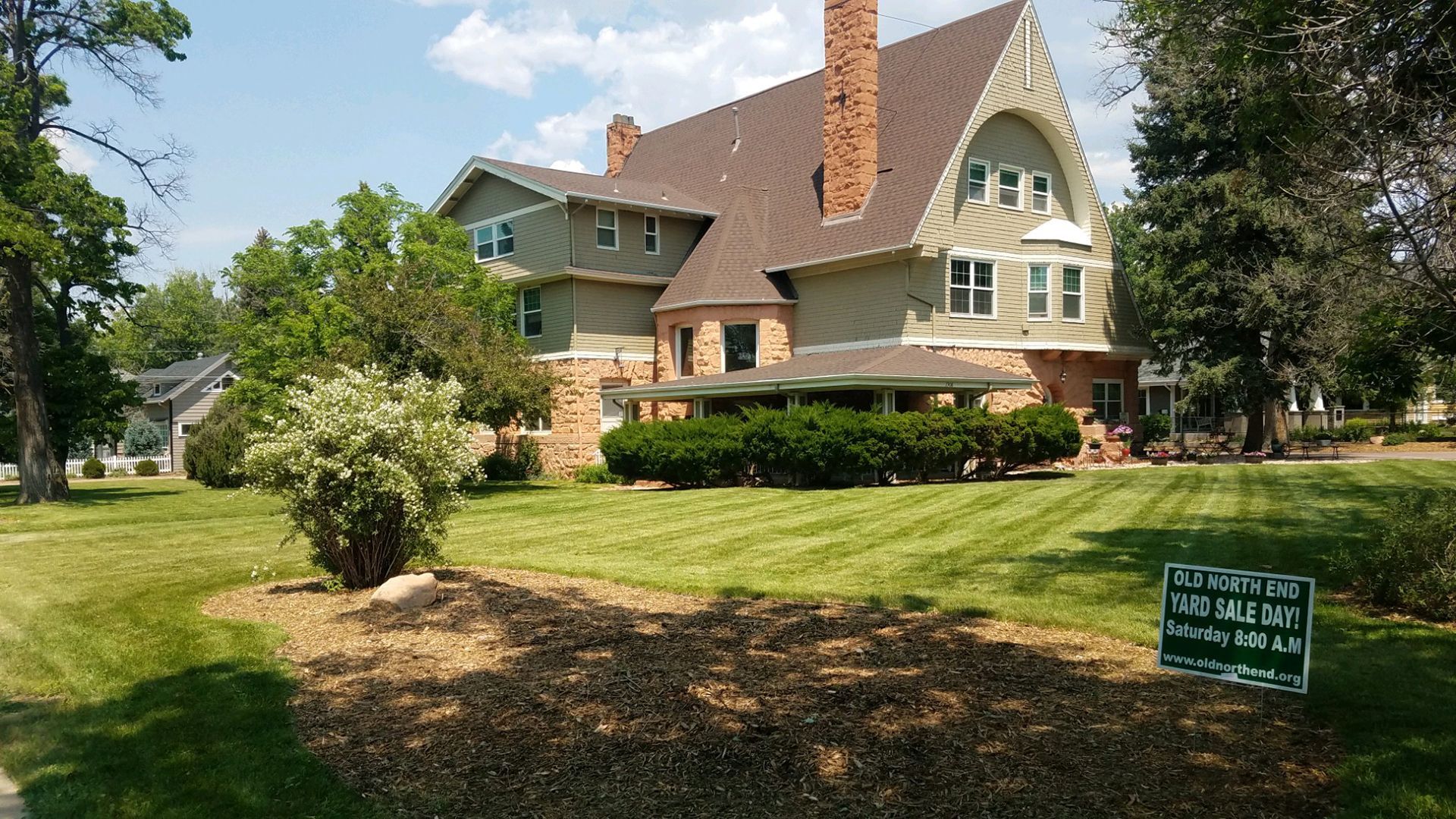 A large house with a lush green lawn in front of it .