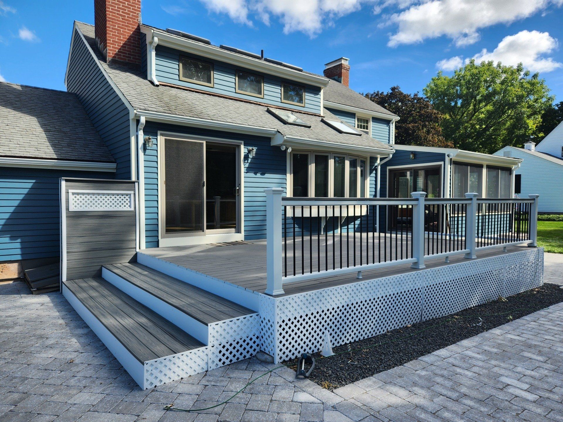 A blue house with a large deck in front of it