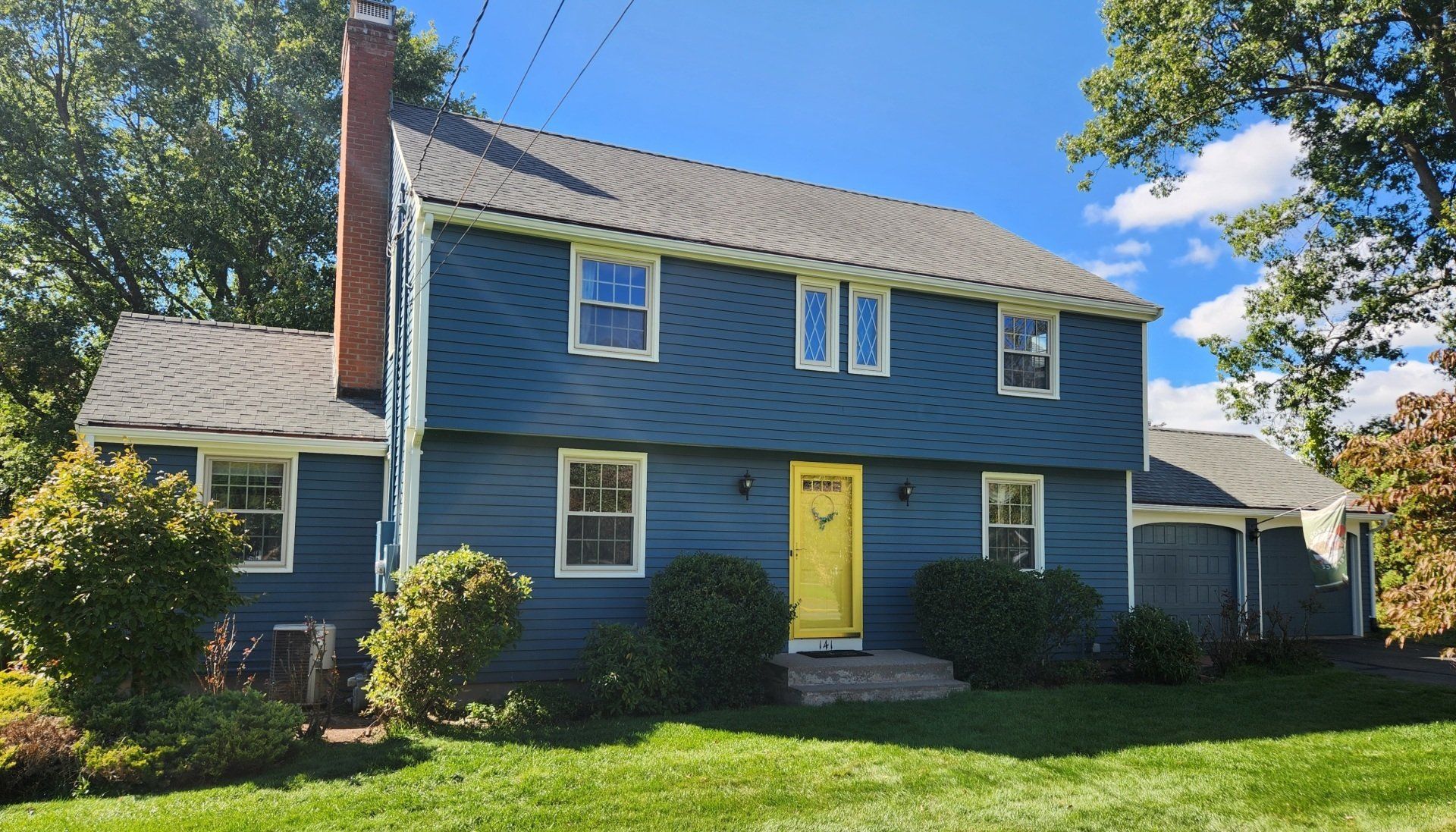 A blue house with a yellow door and windows