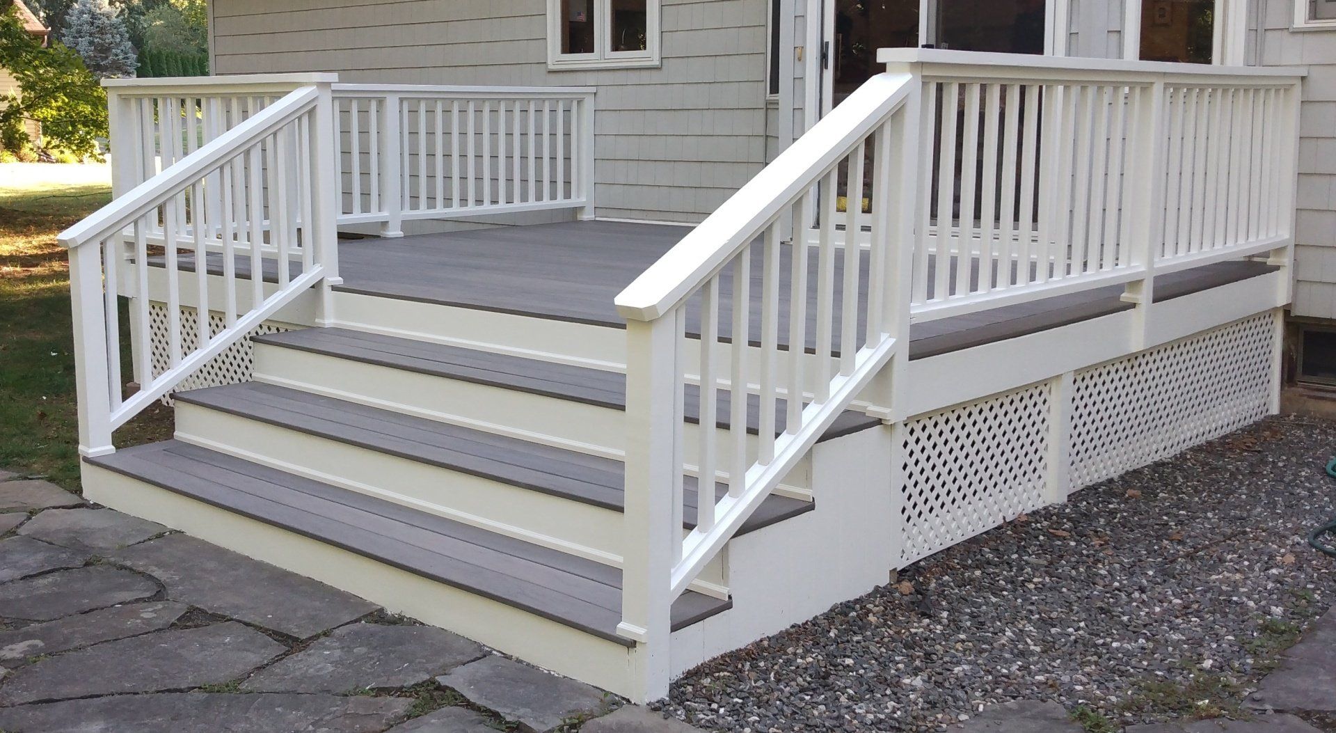 A white deck with stairs and a white railing